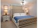 Serene bedroom with a tufted headboard, side tables, and a ceiling fan, creating a relaxing retreat at 101 8Th St, Belleair Beach, FL 33786