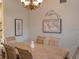 Bright dining room featuring a chandelier, light wood table and chairs, and tasteful wall decorations at 101 8Th St, Belleair Beach, FL 33786