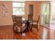 Cozy breakfast nook featuring a hardwood floor, round glass table, and four chairs, with a door to the balcony at 101 8Th St, Belleair Beach, FL 33786