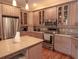 Modern kitchen featuring stainless appliances, granite countertops, and stylish cabinets with glass-front displays at 101 8Th St, Belleair Beach, FL 33786