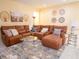 Comfortable living room with a large leather sectional, patterned rug, and glass coffee table, perfect for relaxation at 101 8Th St, Belleair Beach, FL 33786