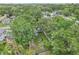 Aerial view of a cozy backyard with a fire pit, seating, and mature trees in a relaxed neighborhood at 1015 13Th Nw Ave, Largo, FL 33770