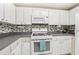 An upclose shot of a kitchen with white appliances, cabinets and grey backsplash at 1015 13Th Nw Ave, Largo, FL 33770