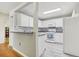 Well-lit kitchen showcases white cabinetry and appliances, complemented by modern gray flooring at 1015 13Th Nw Ave, Largo, FL 33770