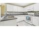 A detailed kitchen view showcases stainless steel sink, gas range and white cabinetry at 1015 13Th Nw Ave, Largo, FL 33770