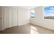 Bright bedroom with terrazzo flooring, two windows, and closet space at 10355 Paradise Blvd # 1003, Treasure Island, FL 33706