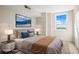 This staged bedroom includes comfortable furnishings, scenic views, and ample natural light at 10355 Paradise Blvd # 1003, Treasure Island, FL 33706
