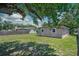 Private backyard with green grass, a well-kept lawn, and neighboring houses in the distance at 10410 Ventura Ave, Tampa, FL 33619
