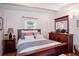 Cozy bedroom featuring a wood frame bed, dresser, and a decorative beam ceiling at 10410 Ventura Ave, Tampa, FL 33619