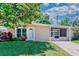 Charming single story home featuring a well manicured lawn, mature trees and a welcoming front porch at 10410 Ventura Ave, Tampa, FL 33619