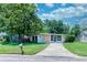 Attractive house featuring a lush front lawn, mature trees, and a welcoming front entrance at 10410 Ventura Ave, Tampa, FL 33619