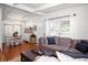 Bright living room with hardwood floors, a comfortable couch, and a dining area at 10410 Ventura Ave, Tampa, FL 33619