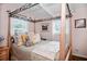 Charming bedroom with a decorative canopy bed, soft lighting, and two windows at 10410 Ventura Ave, Tampa, FL 33619