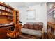 Functional office space with a wooden desk, futon couch, and bookcase at 10410 Ventura Ave, Tampa, FL 33619