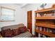 Bright office space featuring a futon couch, natural light, and a bookcase for storage at 10410 Ventura Ave, Tampa, FL 33619