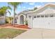 Beautiful single-story home with a two-car garage, well-manicured lawn, and beautiful palm trees at 10538 Juliano Dr, Riverview, FL 33569