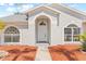 Inviting front entrance with an arched doorway, white door and unique window accents at 10538 Juliano Dr, Riverview, FL 33569