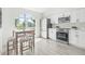 Contemporary kitchen featuring white cabinets, stainless steel appliances, and a dining table near a window at 10538 Juliano Dr, Riverview, FL 33569