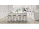 Modern kitchen boasts white cabinets, quartz countertops, stainless steel appliances, and an island with seating at 10538 Juliano Dr, Riverview, FL 33569
