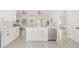 Well-equipped kitchen with modern appliances, white cabinetry, an island with barstools, and wood flooring at 10538 Juliano Dr, Riverview, FL 33569