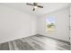 Bright, open bedroom with wood floors, a ceiling fan, and natural light from the window at 1128 Eau Claire Cir, Tampa, FL 33619