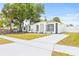 Charming white single-story home featuring a well-manicured lawn and long driveway, under a bright blue sky at 1128 Eau Claire Cir, Tampa, FL 33619