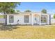 Charming single-story home with a manicured lawn and freshly painted white facade and decorative black accents at 1128 Eau Claire Cir, Tampa, FL 33619