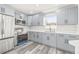 Modern kitchen features gray cabinets, stainless steel appliances, quartz counters, and stylish gray wood-look flooring at 1128 Eau Claire Cir, Tampa, FL 33619