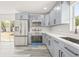 Well-lit kitchen featuring stainless steel appliances, gray cabinets, and a large sink at 1128 Eau Claire Cir, Tampa, FL 33619