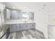 Updated kitchen with stainless steel appliances, gray shaker cabinets, quartz countertops, and gray wood-look flooring at 1128 Eau Claire Cir, Tampa, FL 33619