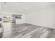 Open living space with modern gray wood-look floors, recessed lighting, and stainless steel kitchen appliances at 1128 Eau Claire Cir, Tampa, FL 33619