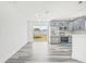 Modern living space with gray wood-look floors, stainless steel appliances, and sliding glass doors to the backyard at 1128 Eau Claire Cir, Tampa, FL 33619