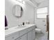 Clean bathroom with a white vanity, a round mirror, neutral tile and fixtures and blinds on the window at 1139 43Rd N Ave, St Petersburg, FL 33703