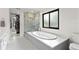 Bright bathroom featuring a soaking tub beneath a window and a glass-enclosed walk-in shower at 1139 43Rd N Ave, St Petersburg, FL 33703