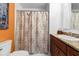 Bathroom featuring a shower with patterned curtain and vanity with brown wood cabinets at 1139 43Rd N Ave, St Petersburg, FL 33703