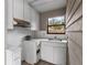 Small kitchenette area featuring white cabinets, sink, and a window view of outdoor greenery at 1139 43Rd N Ave, St Petersburg, FL 33703