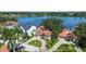 Aerial view showcasing a home's landscaping, circular driveway, and proximity to the waterfront and neighborhood at 1238 Monterey Ne Blvd, St Petersburg, FL 33704