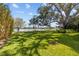 Spacious, well-manicured backyard with lush grass, mature trees, and water views at 1238 Monterey Ne Blvd, St Petersburg, FL 33704