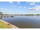 Beautiful waterfront view with a wooden dock on a sunny day under a blue sky with fluffy clouds at 1238 Monterey Ne Blvd, St Petersburg, FL 33704