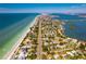 Aerial view of beach community along a coastline featuring homes, roads, and ocean views at 12470 93Rd St, Largo, FL 33773