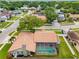 Aerial view of a home featuring a tile roof, screened-in pool, lush landscaping, and fenced yard at 12470 93Rd St, Largo, FL 33773