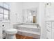 Bathroom featuring a large soaking tub with marble tile surround and bronze fixtures at 12470 93Rd St, Largo, FL 33773