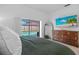Comfortable bedroom with a view of the screened pool, large television, and wooden dresser at 12470 93Rd St, Largo, FL 33773