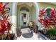 Charming front entrance with arched doorway, decorative plants, and a welcoming bench at 12470 93Rd St, Largo, FL 33773