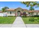 Charming home with a terracotta tile roof, lush landscaping, and inviting front entrance at 12470 93Rd St, Largo, FL 33773