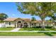 Charming home with terracotta roof, lush landscaping, mature shade trees, and well-maintained lawn at 12470 93Rd St, Largo, FL 33773