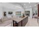 Spacious open-plan living area with kitchen island and view of the pool, seamlessly connecting indoor and outdoor spaces at 12470 93Rd St, Largo, FL 33773