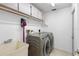 Well-organized laundry room with modern washer and dryer, a utility sink, and built-in storage cabinets at 12470 93Rd St, Largo, FL 33773