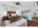 Serene main bedroom with hardwood furniture, neutral tones, and a view of the backyard pool at 12470 93Rd St, Largo, FL 33773