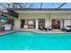 Inviting in-ground pool with tile trim, adjacent to the indoor living space, and outdoor kitchen at 12470 93Rd St, Largo, FL 33773